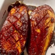 2 Baked Gochujang Aubergine halves in a roasting pan.