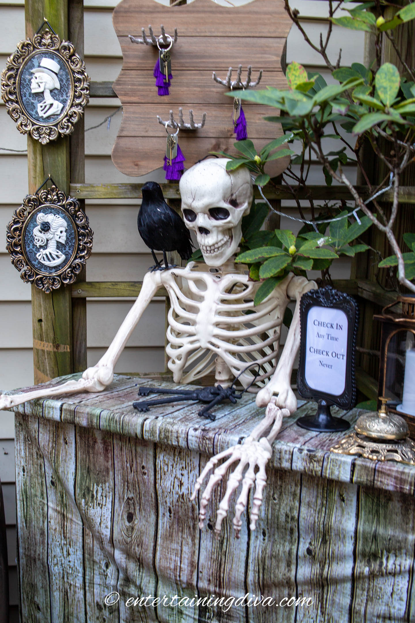 A skeleton front desk clerk at a haunted hotel check in desk with a rack of haunted keys behind it.