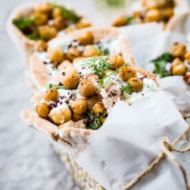 Handheld pita wraps filled with seasoned chicken, crispy chickpeas, and tzatziki sauce.