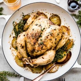 Golden brown roasted chicken with potatoes and herbs, a timeless romantic dinner for two at home.